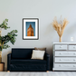 Framed and mounted photograph of the Elizabeth Tower, also known as Big Ben, in central London on a wall above a sofa.