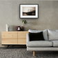 Framed and mounted photograph of Chelsea Bridge on the river Thames in South West London hanging on a wall above a sofa and cupboard