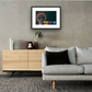 Framed and mounted photograph of London Eye & County Hall At Night on the river Thames in South West London hanging on a wall above a sofa and cupboard