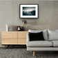 Framed and mounted photograph of Southwark Bridge on the river Thames in London hanging on a wall above a sofa and cupboard