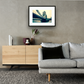 Framed and mounted photograph of Tower Bridge on the river Thames in central London hanging on a wall above a sofa and cupboard