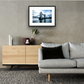 Framed and mounted photograph of Tower Bridge on the river Thames in central London hanging on a wall above a sofa and cupboard